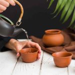 woman-pouring-tea-clay-teacup (1)