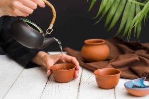 woman-pouring-tea-clay-teacup (1)